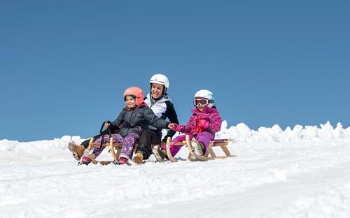 Divertimento con lo slittino per grandi e piccini