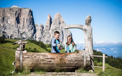 Two kids at a drinking water fountain