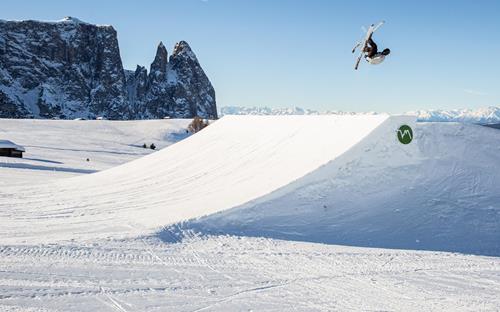 A freestyle skier is doing tricks at the snowpark